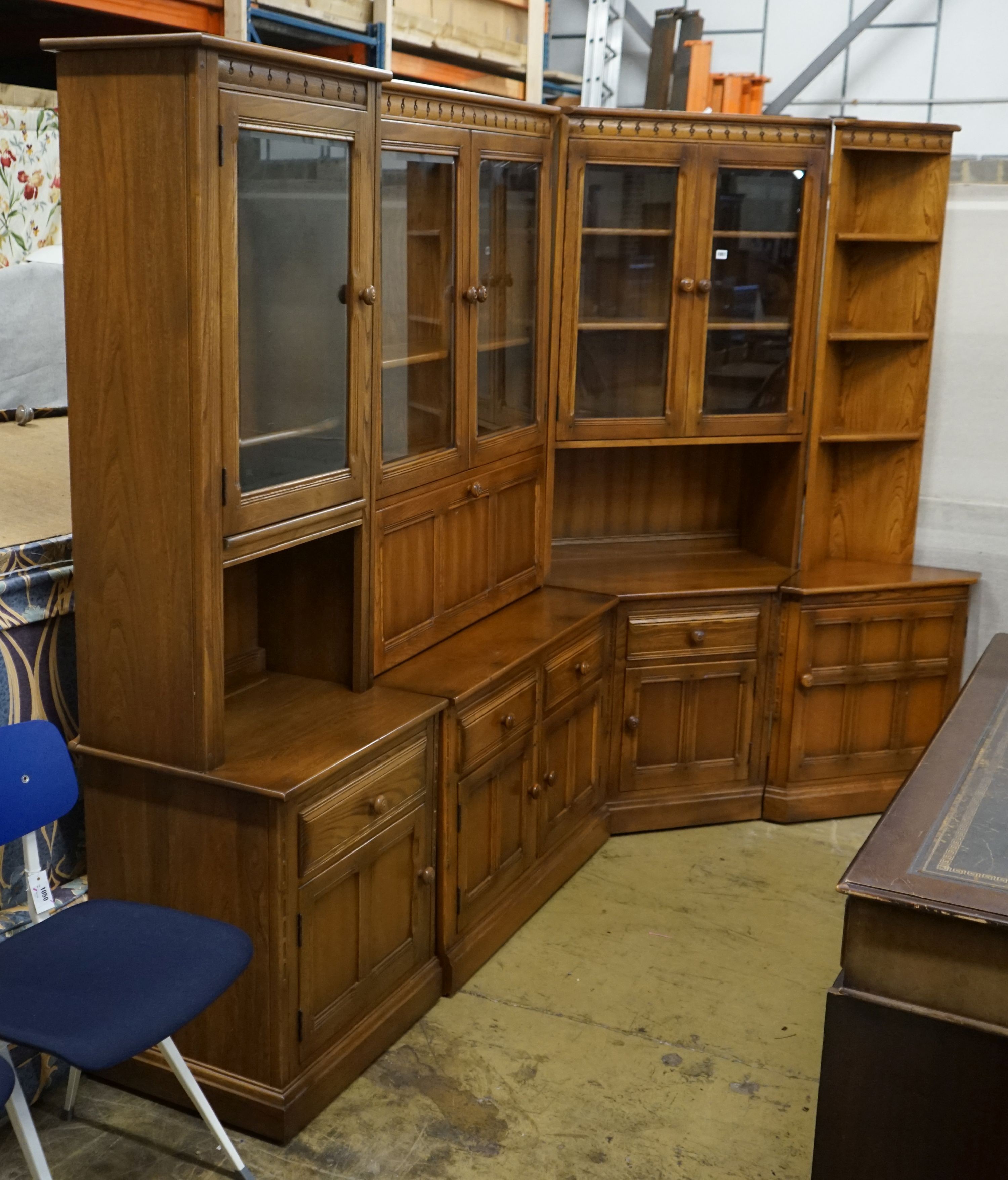 An Ercol elm four section modular wall unit, width 244cm, depth 49cm, height 197cm